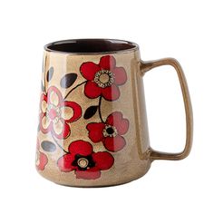 a coffee mug with red flowers painted on the outside and black inside, sitting on a white surface