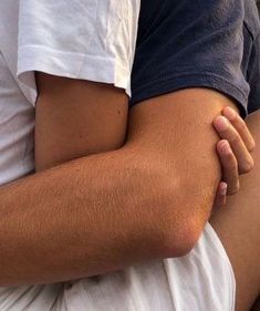 a close up of a person's legs with their arm wrapped around another persons leg