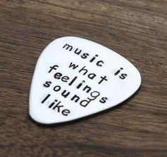 a white guitar pick with the words music is what feeling sounds like