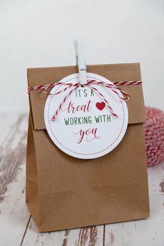 it's a great working with you tag on a brown paper bag next to some yarn