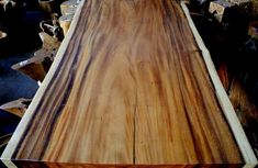 a large wooden table sitting on top of a pile of wood