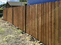 a wooden fence next to a blue building