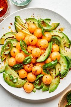 a white plate topped with cucumber and chickpeas covered in seasoning