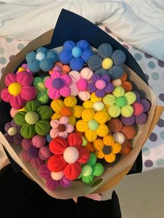 a person holding a bouquet of fake flower hair clips in front of a polka dot bed