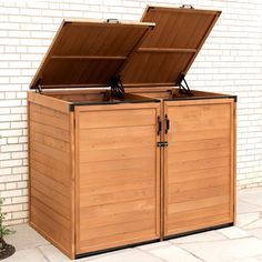 a large wooden storage box with two open doors on the front and back sides, sitting next to a brick wall