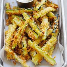 fried zucchini fries in a white tray with dipping sauce