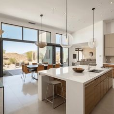 a large kitchen with an island in the middle and lots of windows on both sides