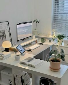 a desk with two computers and books on it