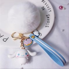 a white plate topped with a keychain and a stuffed animal