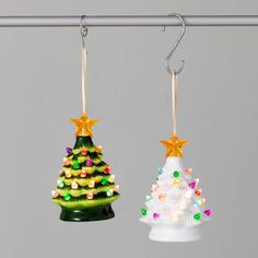 two glass christmas trees hanging from hooks