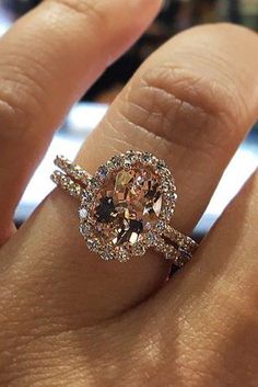 a close up of a person's hand with an engagement ring on their finger