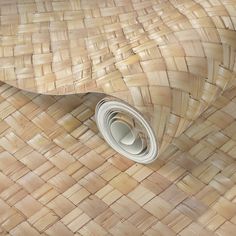 a roll of toilet paper sitting on top of a woven basket pattern wall covering it's surface