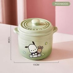 a small green pot with a hello kitty design on the side and a white lid