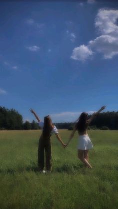 two people in a field holding hands