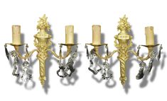 three gold and crystal candelabra with candles on each side, set against a white background