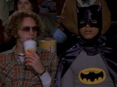 two people dressed up as batman drinking coffee