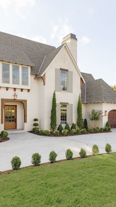 a large white house sitting on top of a lush green field