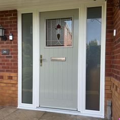 a front door with a glass paneled window and sidelights on the brick building