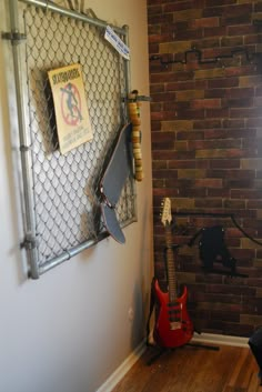 an electric guitar is sitting in front of a brick wall with a sign on it