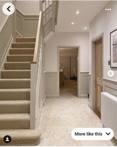 a staircase leading up to the second floor in a house with white walls and beige carpeting