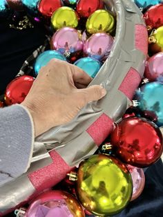 a person's hand holding onto some christmas ornaments