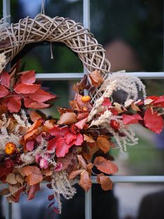 a wreath with dried flowers and leaves on a window sill