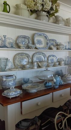 an old china cabinet is filled with blue and white plates, dishes, and vases