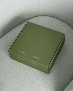 a green box sitting on top of a gray couch