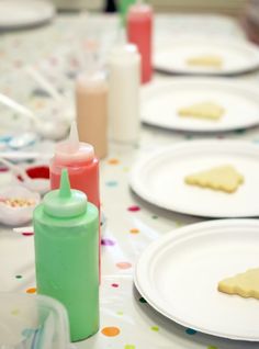 the table is set with white plates and condiments for cookies, milk, and other treats