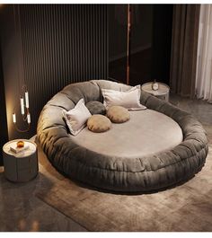 a large round bed with pillows on top of it in the middle of a room