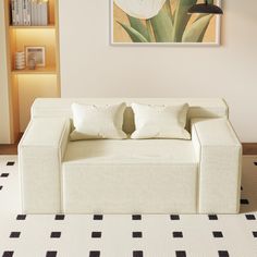 a living room with a white couch and black and white checkered floor tiles on the floor