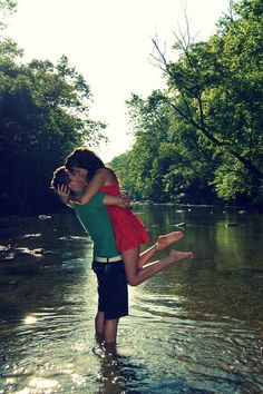 two people are hugging in the water with trees behind them and an instagram page below