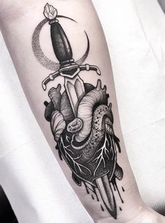 a heart and dagger tattoo on the arm