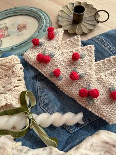 a knitted piece of clothing sitting on top of a wooden table next to a cup