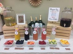 a table topped with bottles of wine and bowls of fruit