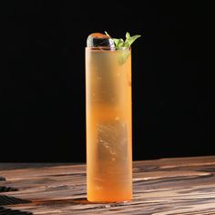 a tall glass filled with liquid sitting on top of a wooden table