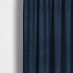 a blue curtain hanging on the side of a white wall