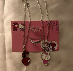 hello kitty necklaces are hanging on a pink card