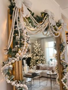 a mirror decorated with christmas decorations and garlands in front of a living room fireplace