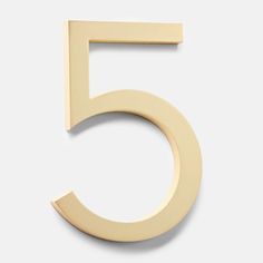 the number five is shown in gold on a white background and it appears to be made out of wood