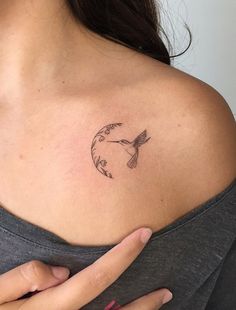 a woman with a bird tattoo on her shoulder and the moon behind her arm is shown