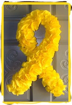 a yellow ribbon is hanging on the door with some flowers around it that says, i love you