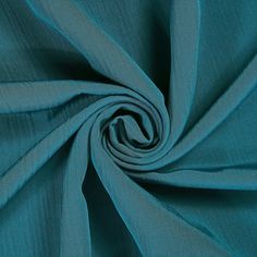 a close up shot of the fabric in teal blue color, with very thin folds