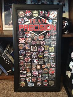 a framed poster with the words team precision surrounded by many different patches and badges on it