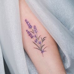 a woman's arm with purple flowers on it