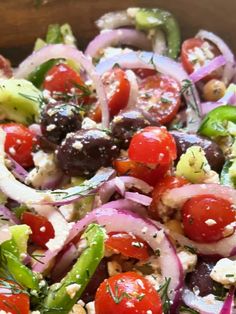 a salad with tomatoes, onions, cucumbers and olives