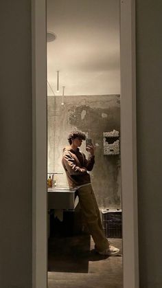 a man is taking a selfie in the mirror with his cell phone while standing next to a sink