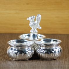 two silver cups with handles on top of each other and a squirrel figurine in the middle