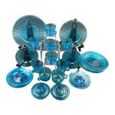 a collection of blue glass dishes and cups