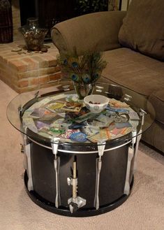 a glass table topped with magazines and a peacock figurine sitting on top of it